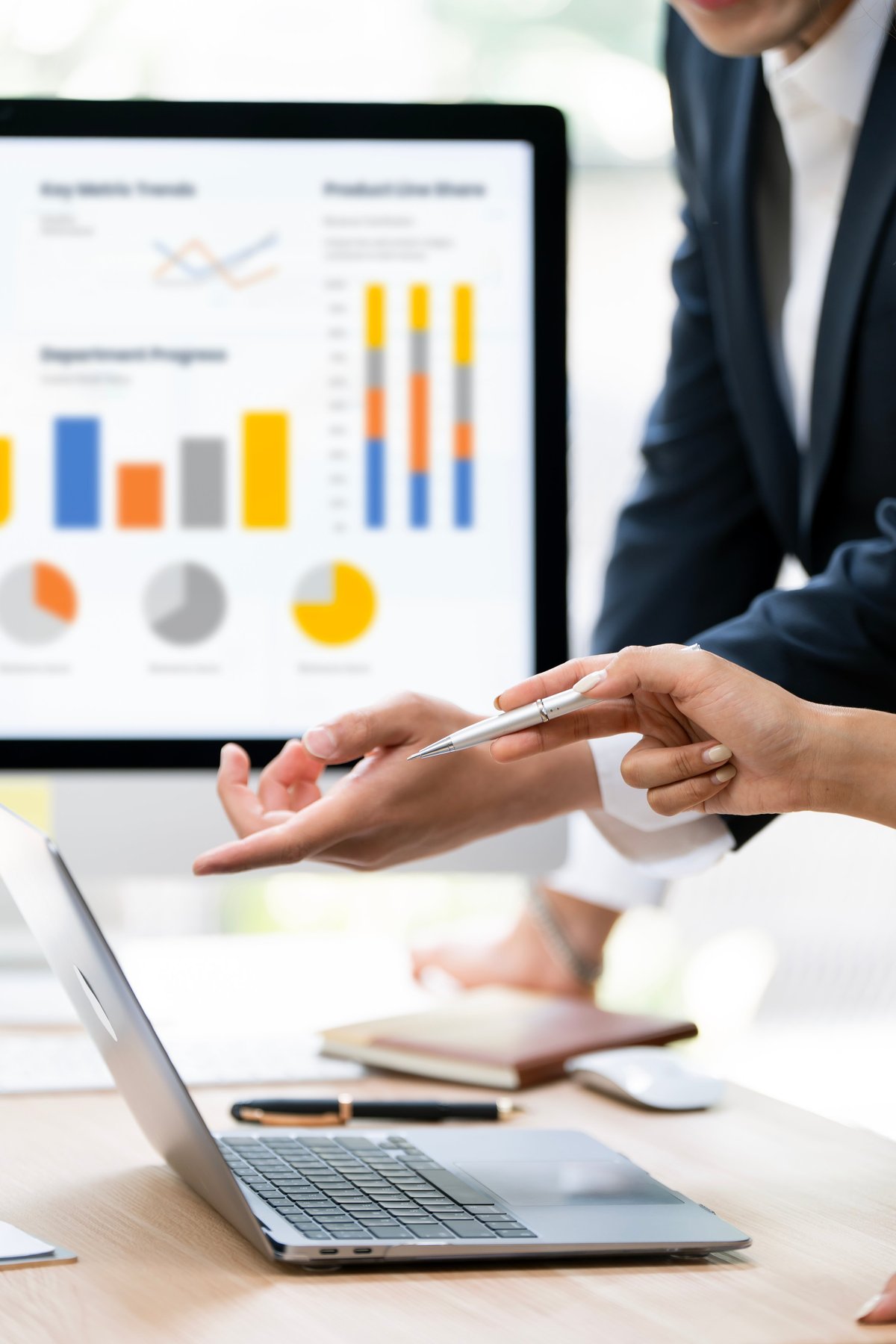 Business partners reviewing financial dashboards and charts on a laptop